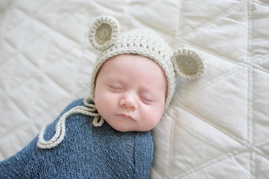 Chicago newborn photographer captures intimate family moment with newborn baby and parents in natural lighting - Image by Kristin Milito Photography, Chicago IL.