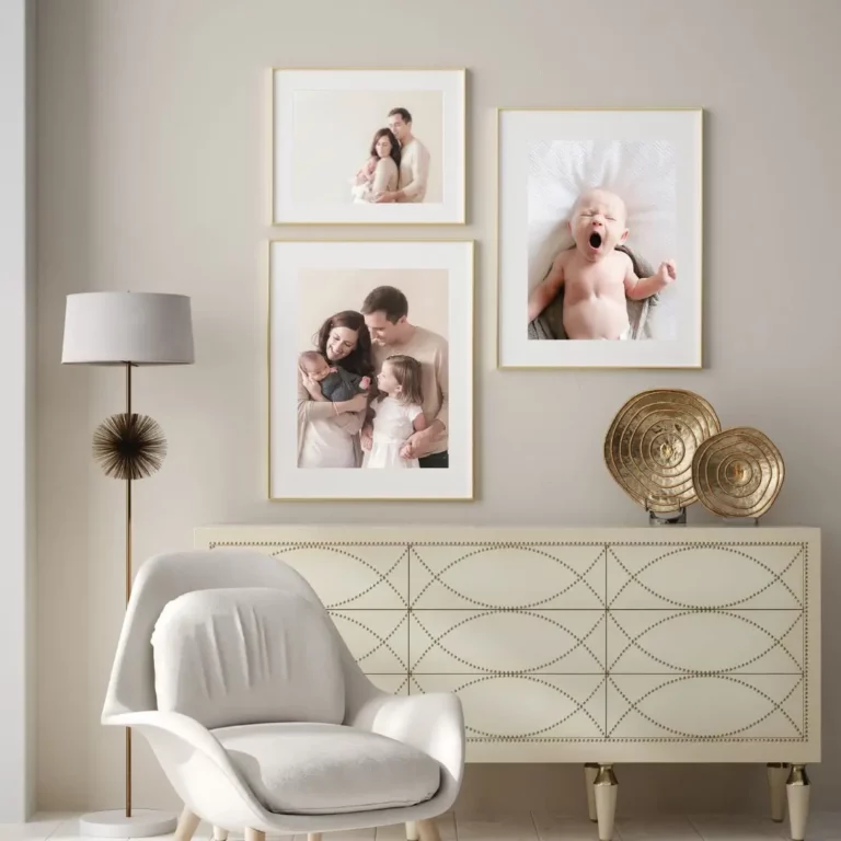 A modern living room with a white armchair, a decorative lamp, a cream sideboard with gold accents, and three family photos in gold frames on the wall above the sideboard. Kristin Milito Photography - Newborn & Maternity Photographer - Chicago IL
